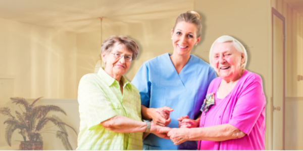 caregiver and two senior women smiling